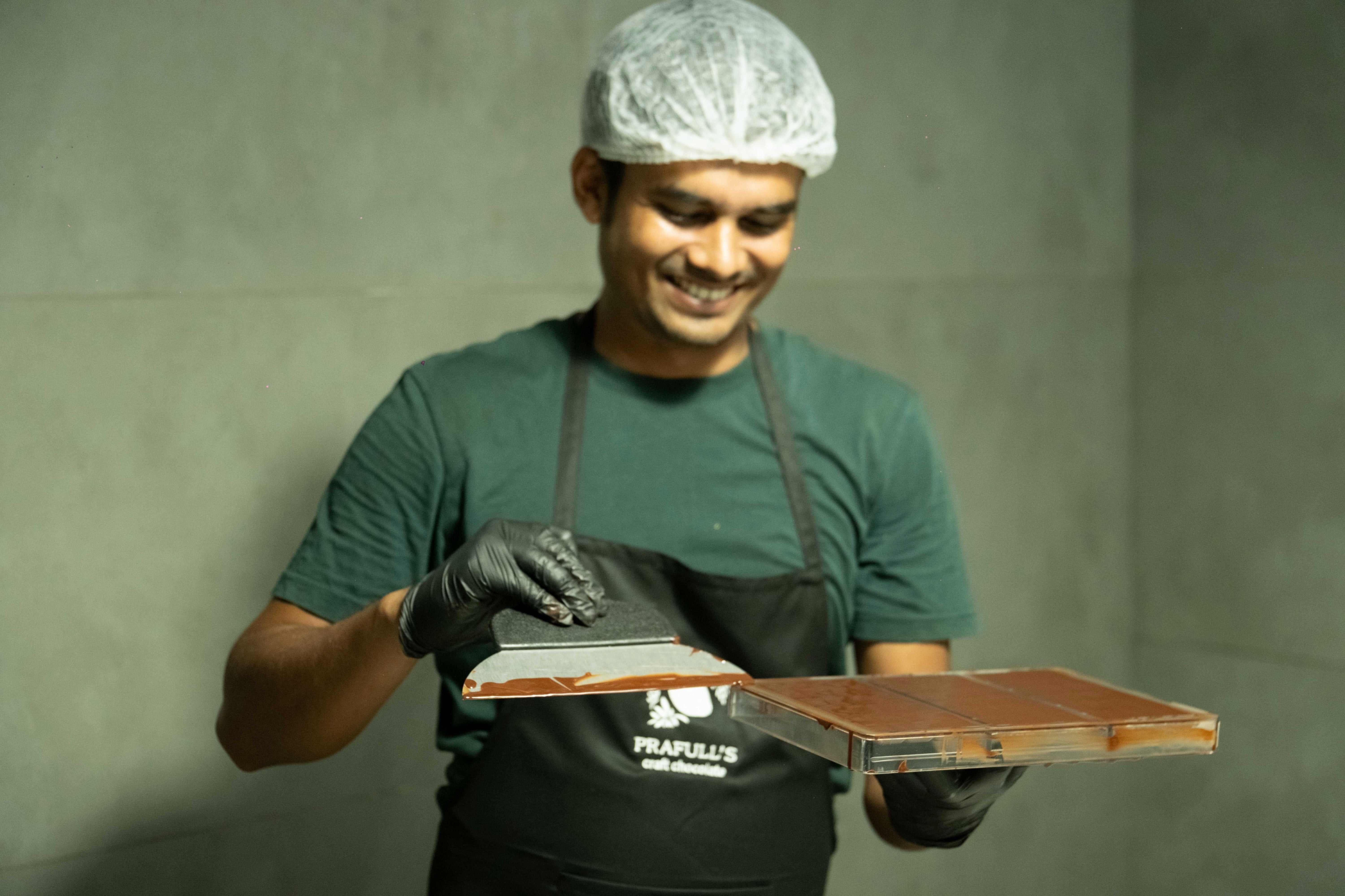 A Prafull's chocolatier moulding a bar by hand